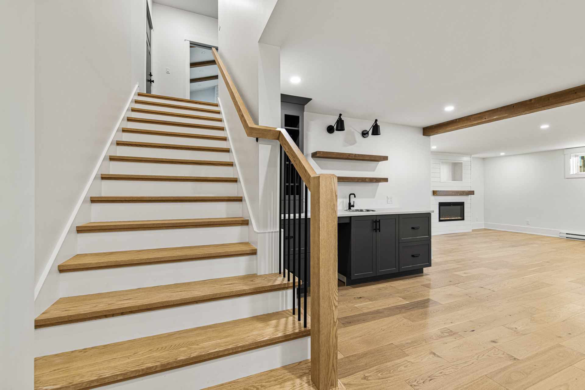 Hardwood stairs, continous railing, beams, shiplap fireplace, fireplace mantel, baseboard.